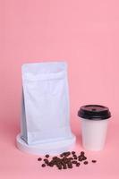 Coffee set mock up on podium isolated over pink background. White standing pouch with valve, beans an paper cup. Realistic set mock up for branding,  template for your design, presentation, promo, ad. photo