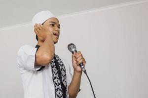 Religious Muslim man doing the call to prayer photo