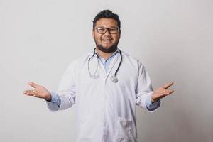 Cheerful male doctor with hand gestures welcoming or offering isolated on white background photo