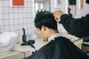 peluquero afeita el cabello del consumidor con maquinilla foto