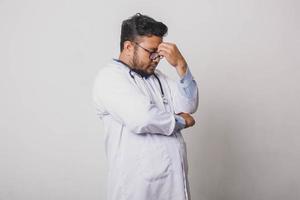 Male doctor looking stressed and nervous isolated on white background photo