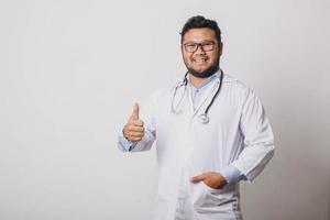 Cheerful male doctor with thumbs up gesture isolated on white background with copy space photo