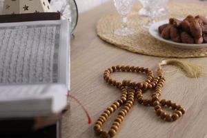 Selective focus of prayer beads with islamic decoration on table photo