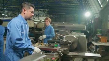 i team di professionisti del settore in uniformi di sicurezza e i partner di ingegneri hanno lavorato con strumenti per la lavorazione dei metalli, macchine per tornio meccanico e officina di pezzi di ricambio nella fabbrica di produzione dell'acciaio. video