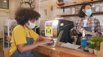 twee jonge café-barista-partners en ondernemer werken met gezichtsmasker in coffeeshop, wachtend op klantenbestelling in nieuwe normale levensstijlservice, mkb-bedrijfsimpact van covid19 pandemische quarantaine. video