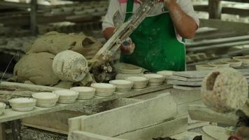 mulher fazendo objetos de barro na oficina de cerâmica. o processo de fazer uma tigela de cerâmica artesanal. artesanato e conceito de empresa de pequeno porte. video