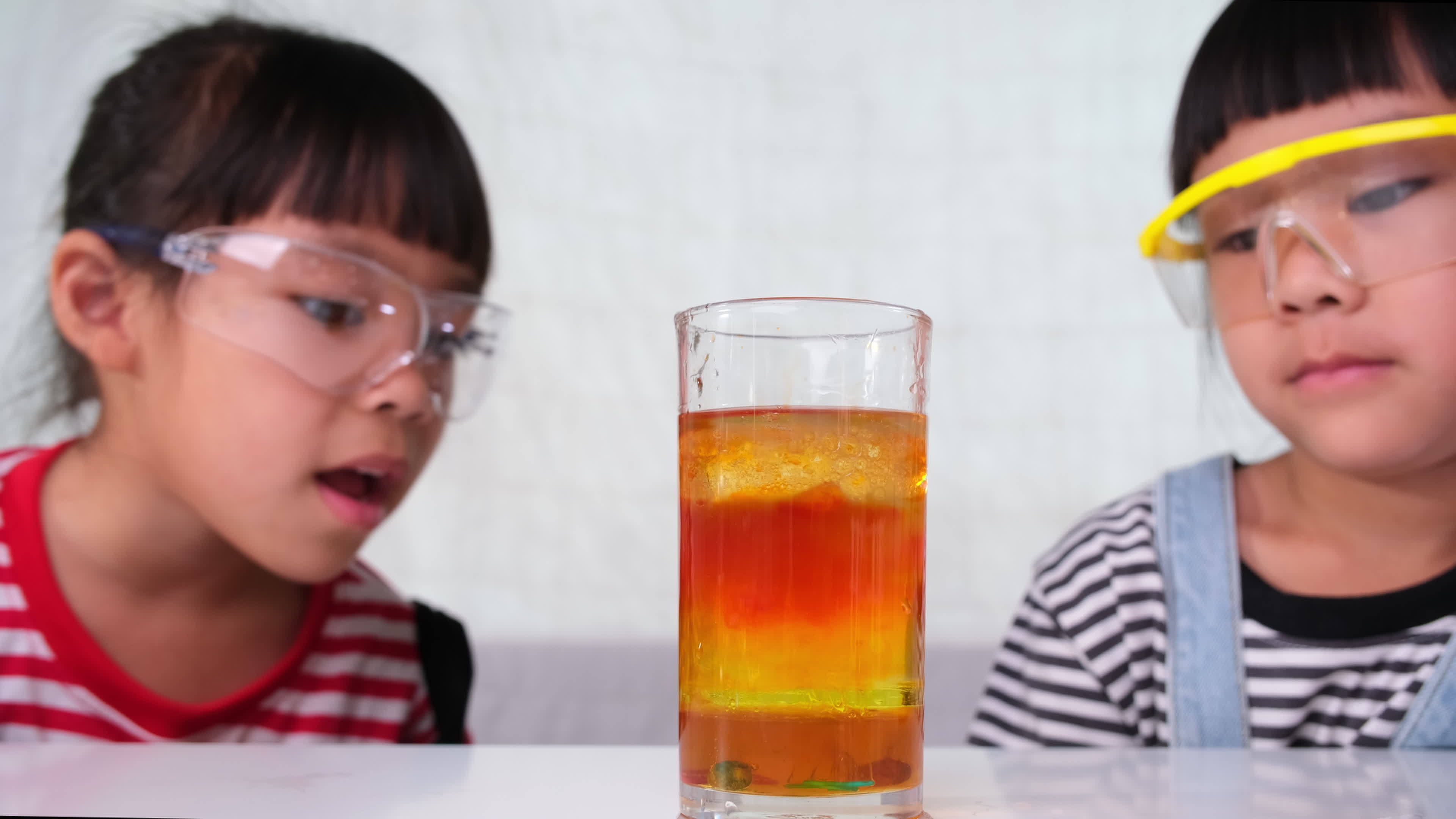 les enfants apprennent et font des expériences scientifiques en classe.  deux petites soeurs jouant à l'expérience scientifique pour l'enseignement  à domicile. des expériences scientifiques faciles et amusantes pour les  enfants à la