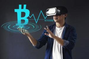 Businessman or professional trader use VR glasses touch cryptocurrency symbol ang graphic on futuristic hologram screen. Virtual trading currency concept. photo