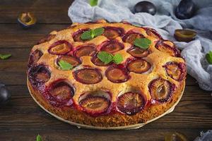 Delicious homemade plum pie on rustic background photo