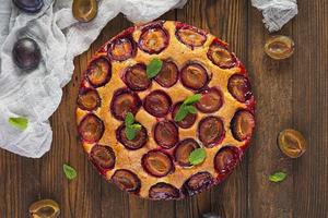 Delicious homemade plum pie on rustic background. Top view photo