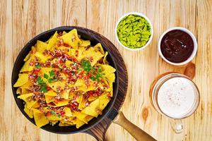 nachos mexicanos con queso. chips de maíz con guacamole, salsa y ketchup de tomate. foto