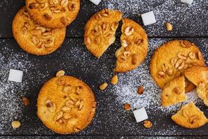 Cookies with peanuts on dark wooden background photo