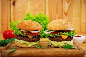 deliciosa hamburguesa hecha a mano sobre fondo de madera. vista cercana foto