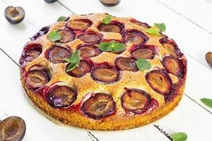 Delicious homemade plum pie on white background photo