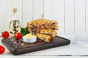 Club sandwich with ham, cheese, tomato, salad and chips photo