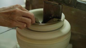 primo piano di una donna che lavora su un tornio da vasaio che fa oggetti di argilla nel laboratorio di ceramiche. il processo di formazione di una ciotola di ceramica fatta a mano. video