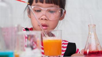 kinder lernen und machen naturwissenschaftliche experimente im klassenzimmer. Kleines Mädchen, das wissenschaftliches Experiment für den Heimunterricht spielt. einfache und unterhaltsame wissenschaftliche Experimente für Kinder zu Hause. video