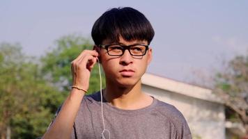 feliz jovem asiático usando fone de ouvido. video