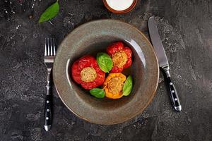 Colorful stuffed peppers with rice and minced meat on wooden background. Top view.