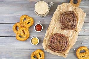 Food menu for Oktoberfest. Sausage with different sauce, pretzel and glass of dark beer photo