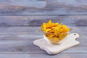 nachos mexicanos con queso. chips de maíz aislado sobre fondo de madera foto