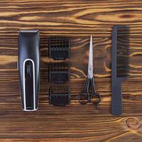 Hairdresser tools on wooden background. Haircut accessories concept. Top view photo