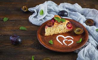 Delicious homemade plum pie on rustic background photo