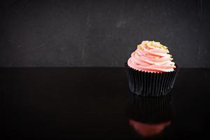 sabrosos cupcakes coloridos aislados sobre fondo oscuro. deliciosa magdalena foto