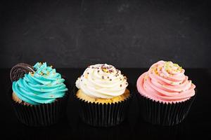 Tasty colorful cupcakes isolated on dark background. Delicious cupcake photo