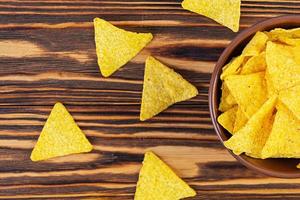 Mexican nachos with cheese. Corn chips isolated on wooden background photo