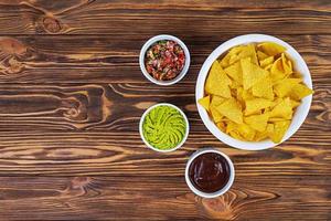 Mexican nachos with cheese. Corn chips with guacamole, salsa and tomato ketchup. photo