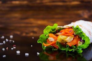 Delicious shawarma sandwich on wooden background photo