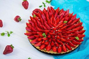 Delicious tart with strawberry on wooden background photo