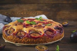 Delicious homemade plum pie on rustic background photo