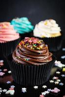 Tasty colorful cupcakes isolated on dark background. Delicious cupcake photo