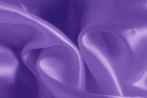 The texture of the proton purple cloth with waves and shrugs. Shiny fabric. photo