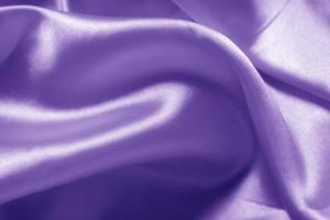 The texture of the proton purple cloth with waves and shrugs. Shiny fabric. photo