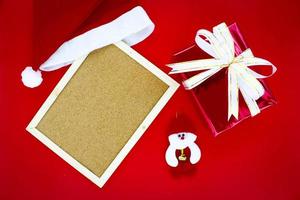 Many gift boxes with Santa hat and wooden frame on Christmas concept. photo