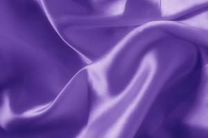 The texture of the proton purple cloth with waves and shrugs. Shiny fabric. photo