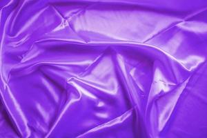 The wrinkled surface of the proton purple cloth. The purple shiny cloth.