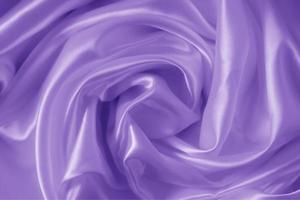 The texture of the proton purple cloth with waves and shrugs. Shiny fabric. photo