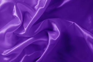 The texture of the proton purple cloth with waves and shrugs. Shiny fabric. photo