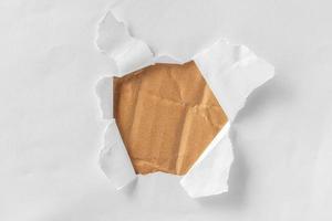 papel blanco roto, perforado, dentro es cartón marrón. foto