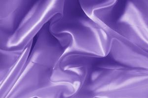The texture of the proton purple cloth with waves and shrugs. Shiny fabric. photo