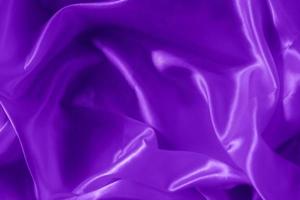 The texture of the proton purple cloth with waves and shrugs. Shiny fabric. photo
