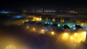 Niebla de 8k entre casas en la ciudad por la noche. video