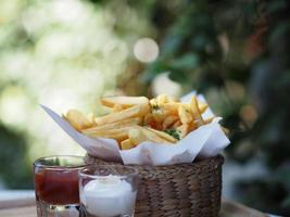 papas fritas, papas fritas papas fritas crujientes amarillas en una canasta de madera, merienda deliciosa foto