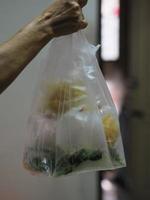 sopa picante de fideos de cerdo tom yam con hierba de limón, pasta fría y jugo de lima en una bolsa de plástico transparente, comida tailandesa para llevar a casa foto