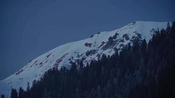 Efecto de tiempo de transición de noche a día de 8k en el bosque de montaña nevada en la mañana de invierno
