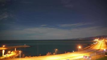 Carretera de 8k y luces del puerto junto al mar por la noche video